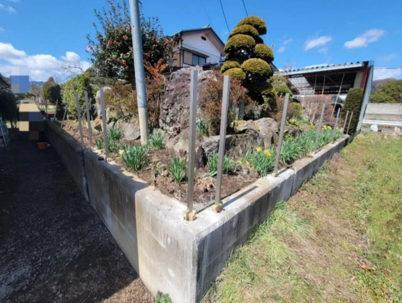 柱建て工程の全体像。境界ラインに沿ってフェンスの骨格が出来上がりつつある。
