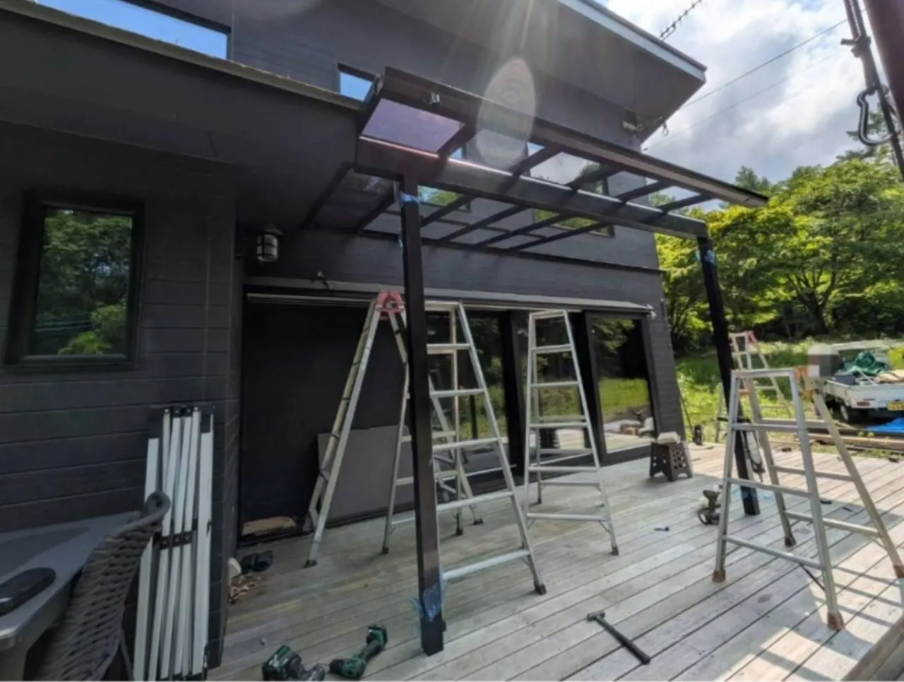 デッキと建物の寸法を確認しながらテラス屋根を組み立てる様子